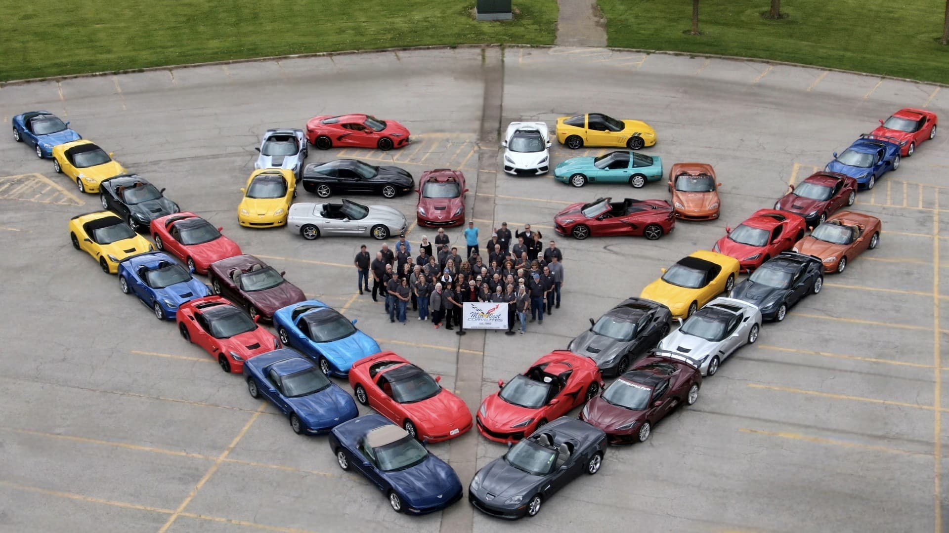 Mid-West Corvettes members gathered between two rows of their colorful Corvettes